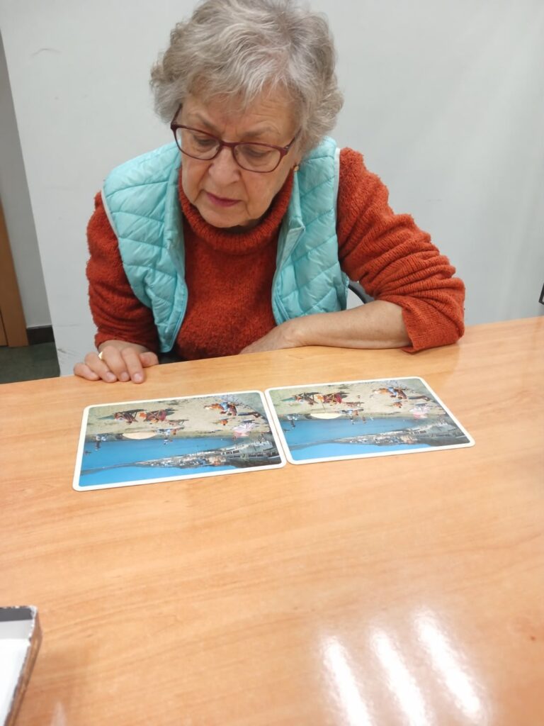 Ejercicio de estimulación cognitiva con tarjetas de imágenes sobre una mesa